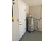 Garage showcasing the hot water heater and the neutral paint used in the garage at 186 Dan River Dr, Spring Hill, FL 34606