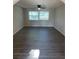 Bright living room featuring wood floors, ceiling fan, and a large window with natural light at 186 Dan River Dr, Spring Hill, FL 34606