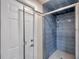 Bathroom featuring blue tiled shower with glass door at 186 Dan River Dr, Spring Hill, FL 34606