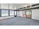 This sunroom includes carpet flooring, sliding glass doors, and multiple windows at 186 Dan River Dr, Spring Hill, FL 34606