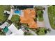 An aerial shot showcases a home with a uniquely patterned red tile roof, a pool, and water access at 2012 Carolina Ne Cir, St Petersburg, FL 33703