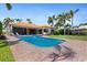 Tranquil pool area with a hot tub, brick paver patio, and lush tropical landscaping at 2012 Carolina Ne Cir, St Petersburg, FL 33703