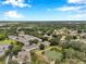 An aerial view of a vibrant community with townhomes and a pond set amongst a beautiful, natural landscape at 2531 Earlswood Ct, Brandon, FL 33510