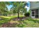 Backyard of home with pond, mature trees, and green grass at 2531 Earlswood Ct, Brandon, FL 33510