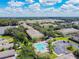 Aerial view of community featuring lush landscaping, a swimming pool, and ample parking on a bright, sunny day at 256 Castlekeeper Pl, Valrico, FL 33594