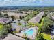 Aerial view of a community with a swimming pool, parking, lush trees, and well-maintained buildings at 256 Castlekeeper Pl, Valrico, FL 33594