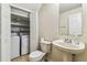 Bathroom featuring a toilet, sink, and a closet with a washer and dryer at 256 Castlekeeper Pl, Valrico, FL 33594