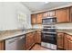 Kitchen featuring granite countertops, stainless appliances, and wood cabinets at 256 Castlekeeper Pl, Valrico, FL 33594