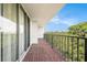 An open balcony with red brick flooring provides a peaceful retreat with lush views at 2699 Seville Blvd # 705, Clearwater, FL 33764