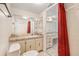 Bright bathroom featuring marble countertop and red shower curtain at 2699 Seville Blvd # 705, Clearwater, FL 33764