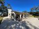 Exterior view of the building with seating area and lush trees at 2699 Seville Blvd # 705, Clearwater, FL 33764