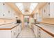 Bright galley kitchen features white appliances, and a clear view into the living area at 2699 Seville Blvd # 705, Clearwater, FL 33764