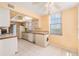 Compact kitchen featuring essential appliances, cabinets, and tile flooring at 2699 Seville Blvd # 705, Clearwater, FL 33764