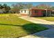 Charming brick home with a well-maintained lawn and a concrete driveway at 318 Banana St, Tarpon Springs, FL 34689