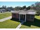 Charming brick home with a cozy front porch and well-manicured lawn, offering a welcoming curb appeal at 318 Banana St, Tarpon Springs, FL 34689