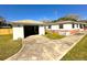 Exterior view of a white house and garage with a yard needing landscape at 318 Banana St, Tarpon Springs, FL 34689