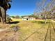 A spacious, grassy lot with a building and fencing in the background at 318 Banana St, Tarpon Springs, FL 34689