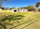 View of a spacious, grassy yard with a house and detached garage in the background at 318 Banana St, Tarpon Springs, FL 34689