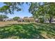 Spacious backyard with mature trees, lush green grass, and a view of the single-story home at 319 Kelsey Way, Sun City Center, FL 33573