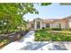 Charming single-story home featuring lush landscaping and a welcoming front walkway leading to the front door at 319 Kelsey Way, Sun City Center, FL 33573