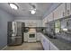 Well-lit kitchen featuring ample white cabinetry, granite countertops, and stainless steel appliances at 319 Kelsey Way, Sun City Center, FL 33573