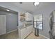 Bright kitchen with white cabinets and stainless appliances, showing an attached storage area with shelving at 319 Kelsey Way, Sun City Center, FL 33573