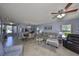 Comfortable living room with tile floors, ceiling fan, and a view of the dining area at 319 Kelsey Way, Sun City Center, FL 33573