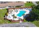Aerial view of a community pool featuring lounge chairs, tables, and lush landscaping at 319 Kelsey Way, Sun City Center, FL 33573