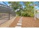 Lush backyard with stone path leading to a screened pool enclosure at 3215 W Fair Oaks Ave, Tampa, FL 33611