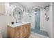 Bright bathroom with a glass-enclosed shower featuring blue patterned tile and a wood vanity with a marble countertop at 3215 W Fair Oaks Ave, Tampa, FL 33611