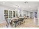 Dining area with a modern chandelier, large windows, and hardwood floors, perfect for entertaining at 3215 W Fair Oaks Ave, Tampa, FL 33611