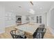 Bright dining room featuring light wood floors, a modern chandelier, and a large table set for entertaining at 3215 W Fair Oaks Ave, Tampa, FL 33611