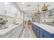 Stylish kitchen featuring white cabinetry, stainless steel appliances, a large island, and modern pendant lights at 3215 W Fair Oaks Ave, Tampa, FL 33611