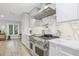 Contemporary kitchen with stainless appliances, sleek white cabinetry, and an industrial-style range hood at 3215 W Fair Oaks Ave, Tampa, FL 33611