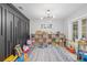 Spacious playroom with stylish light fixture, decorative wall and organized storage at 3215 W Fair Oaks Ave, Tampa, FL 33611