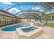 Pool and hot tub on a paved patio, enclosed by a screened enclosure at 3215 W Fair Oaks Ave, Tampa, FL 33611
