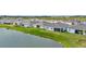 Peaceful backyard view of a home alongside a serene pond, complemented by lush green landscaping at 3504 Golden Wheat Ln, Plant City, FL 33565