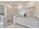 Contemporary bathroom showcasing a glass shower, dual sinks, and white cabinets with granite counters at 3504 Golden Wheat Ln, Plant City, FL 33565