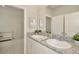 Bright bathroom with double sinks, granite counters, and views into an adjacent room with crib at 3504 Golden Wheat Ln, Plant City, FL 33565