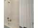 Bathroom shower and tub with white tile and neutral-colored shower curtain at 3504 Golden Wheat Ln, Plant City, FL 33565