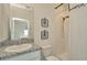 Well-lit bathroom featuring white tile, a shower, decorative botanical prints, and a granite countertop at 3504 Golden Wheat Ln, Plant City, FL 33565