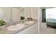 Bathroom with double sinks, granite counters, and views into an adjacent bedroom at 3504 Golden Wheat Ln, Plant City, FL 33565