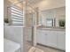 Modern bathroom featuring a glass shower, white cabinetry, granite countertops, and stylish tile work at 3504 Golden Wheat Ln, Plant City, FL 33565