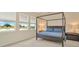 Serene bedroom features a four-poster bed, ample natural light, and a tranquil view overlooking a pond at 3504 Golden Wheat Ln, Plant City, FL 33565