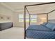 Bright bedroom featuring three large windows, canopy bed, and chest of drawers at 3504 Golden Wheat Ln, Plant City, FL 33565