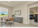 Bright dining area with a round wood table, modern gray console, and a picturesque view from the window at 3504 Golden Wheat Ln, Plant City, FL 33565