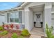 Inviting front entrance with stylish gray door, decorative wreath, elegant landscaping, and stone accents at 3504 Golden Wheat Ln, Plant City, FL 33565