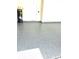 Spacious garage with a durable, epoxy-coated floor, freshly painted walls, and a hot water heater at 3504 Golden Wheat Ln, Plant City, FL 33565