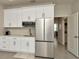 Modern kitchenette with stainless steel refrigerator, white cabinets, and an adjacent dining area at 3504 Golden Wheat Ln, Plant City, FL 33565