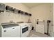 A bright laundry room featuring modern washer and dryer units, storage shelves, and utility sink at 3504 Golden Wheat Ln, Plant City, FL 33565